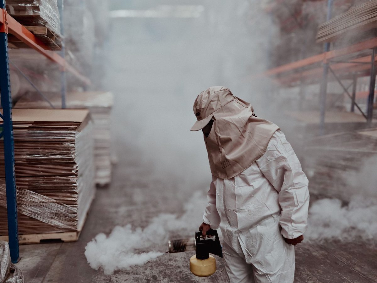 Technician fogging a warehouse aisle